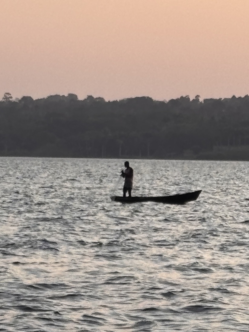 A fisherman on a lake near AVN's Uganda origin — the watershed AVN maps for water-use and erosion risk data.